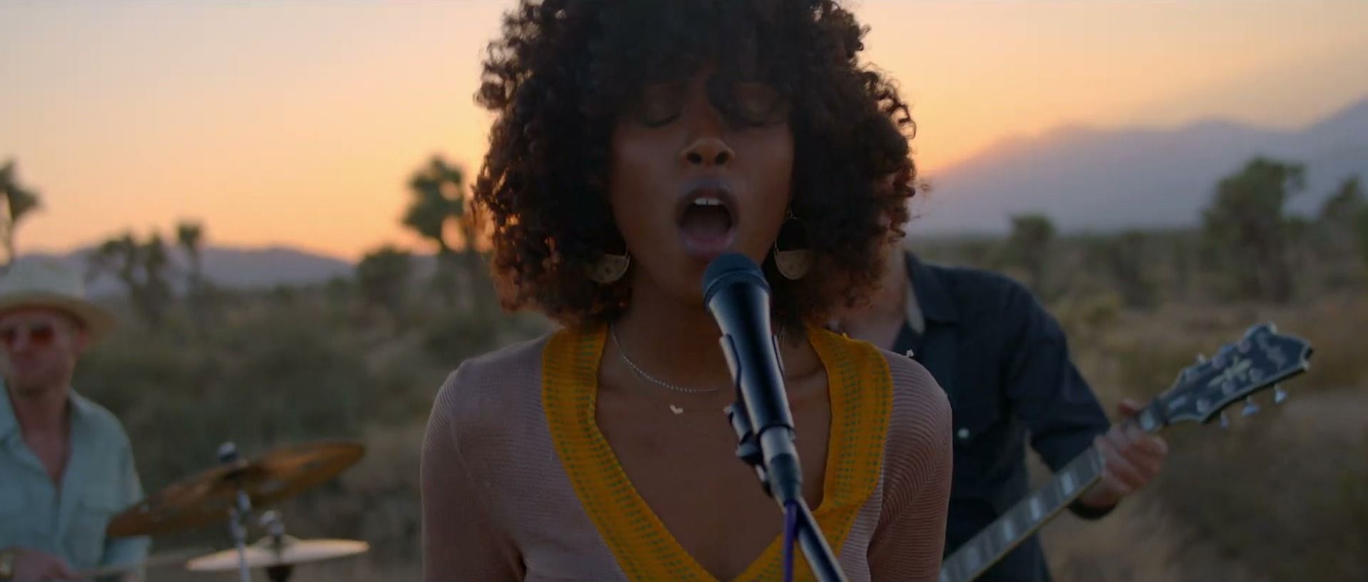 A singer belts into a microphone at sunset in the Joshua Tree desert, her band playing behind her, a still from CHERONE’s “Lavender Sky”.