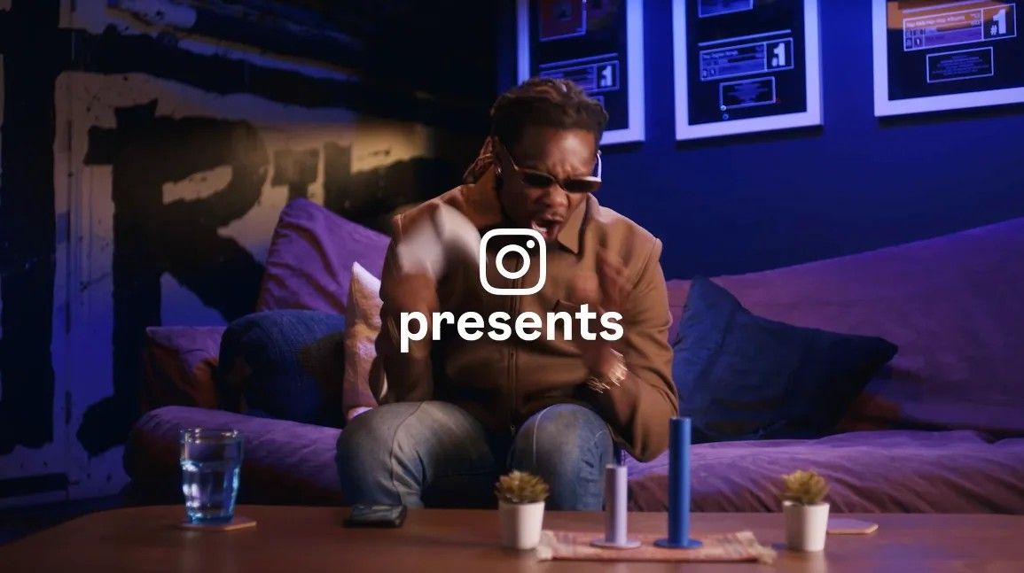 A man in sunglasses and a tan jacket reacts on a purple sofa under framed records, with an Instagram "presents" title over the shot.
