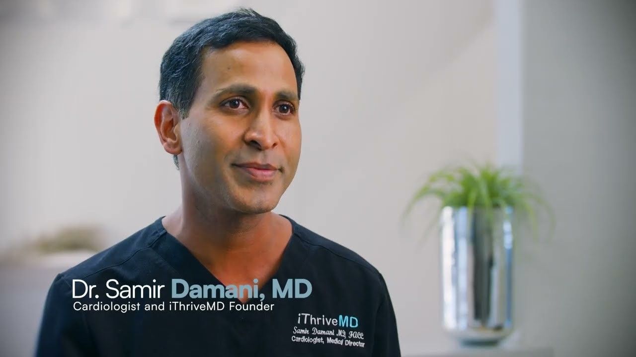 Dr. Samir Damani, cardiologist and iThriveMD founder, in navy scrubs above his name caption.