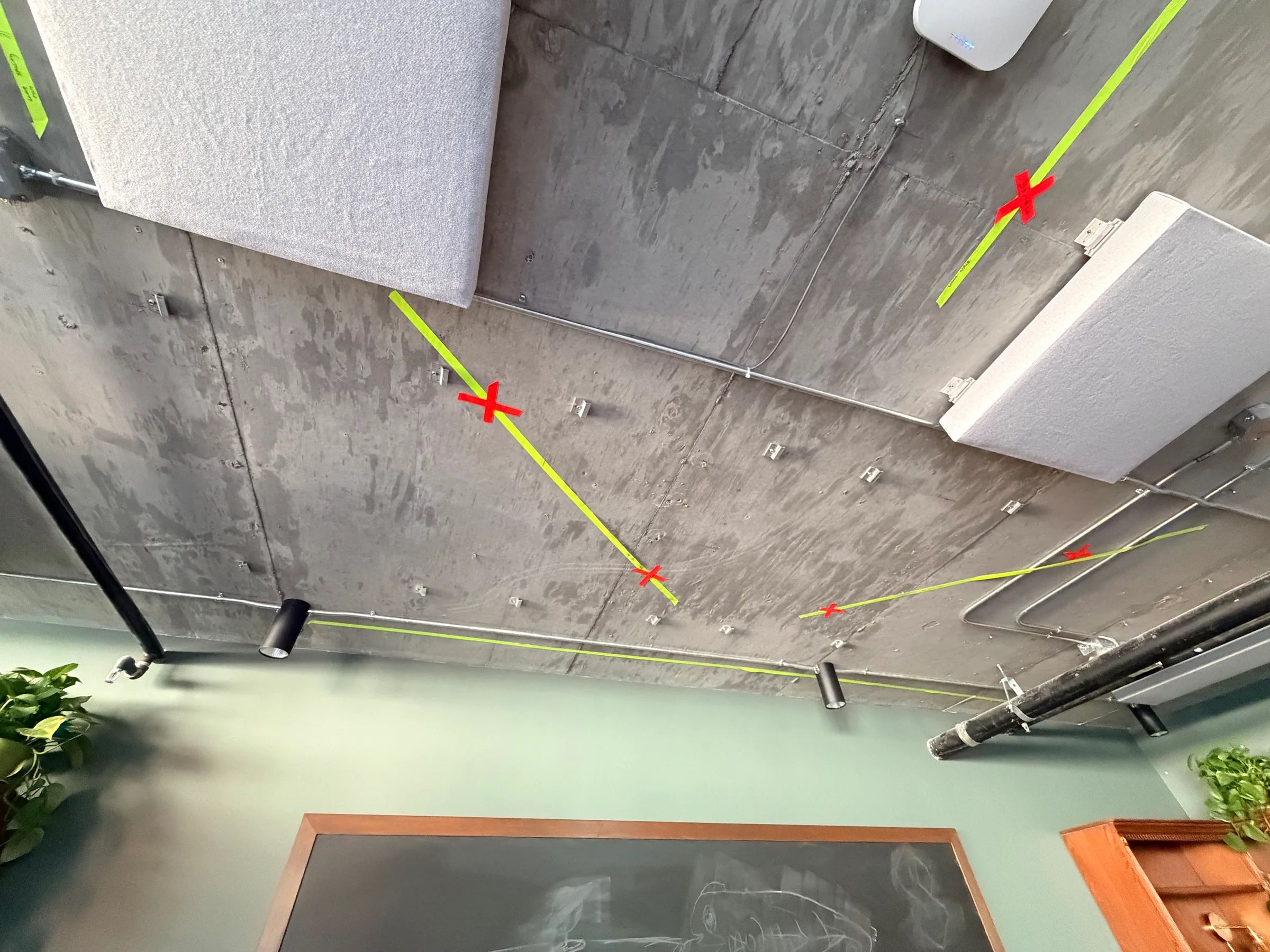 A concrete ceiling with mount points marked in red and cable runs marked in green