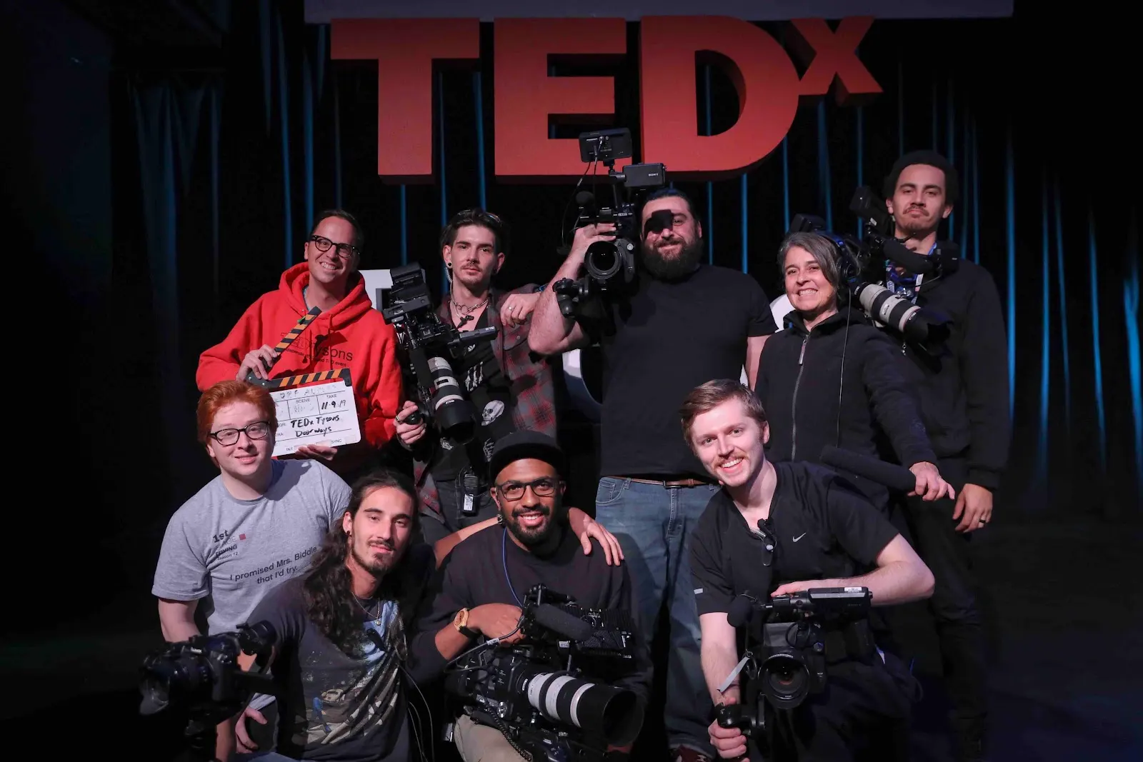 Honey's crew on the TEDx stage with cinema cameras, a clapperboard and a boom microphone